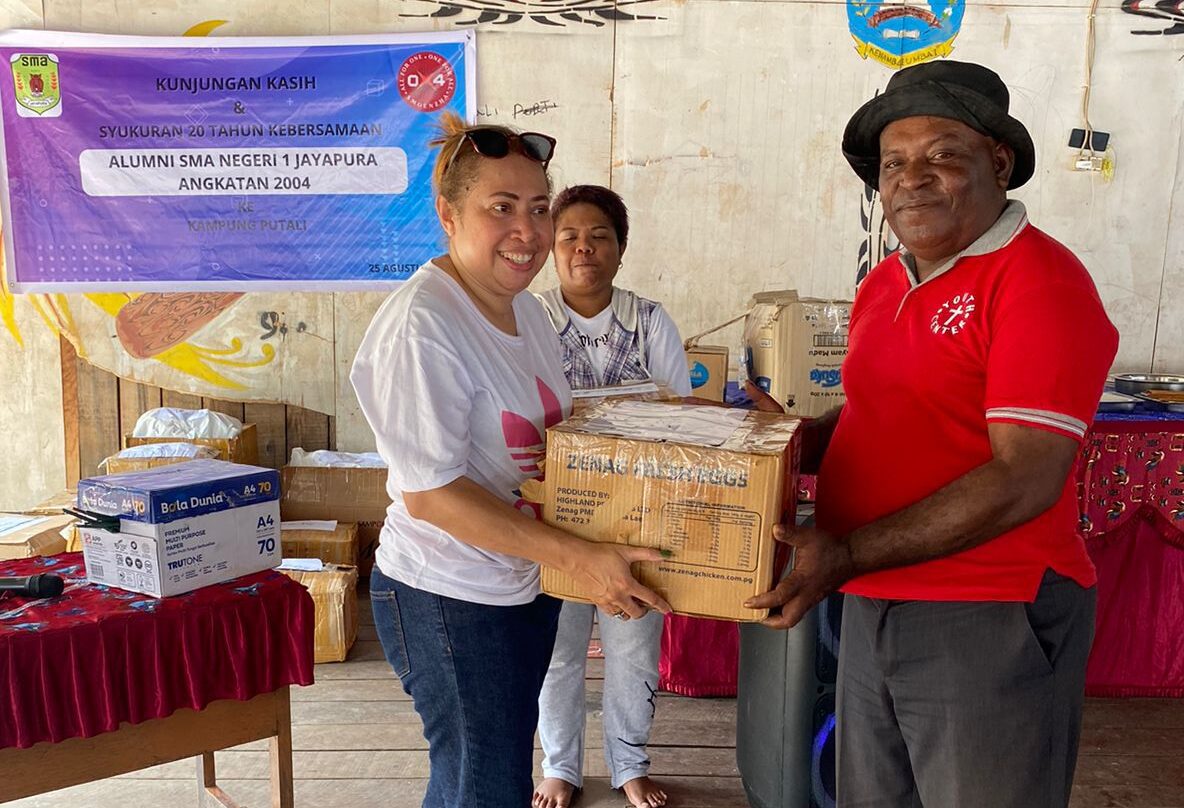 Rolen Sawaki, mewakili Alumni Smoenzha 2004 menyerahkan sejumlah bungkisan kunjungan kasih kepada Ondo Kampung Putali.