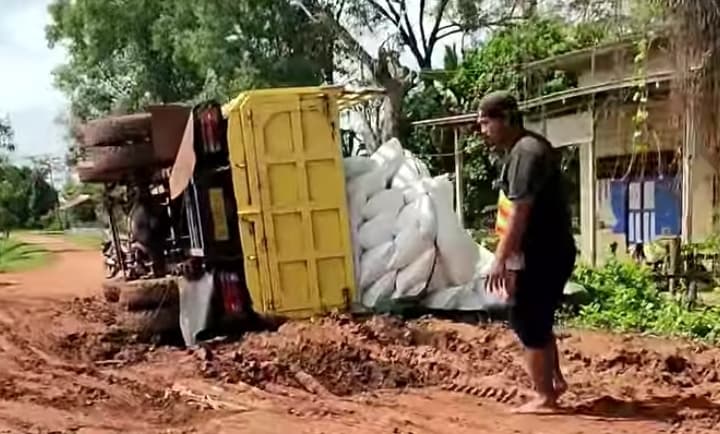 Satu unit truk bermuatan beras, terguling akibat kondisi jalan di kampung Candra Jaya rusak parah.