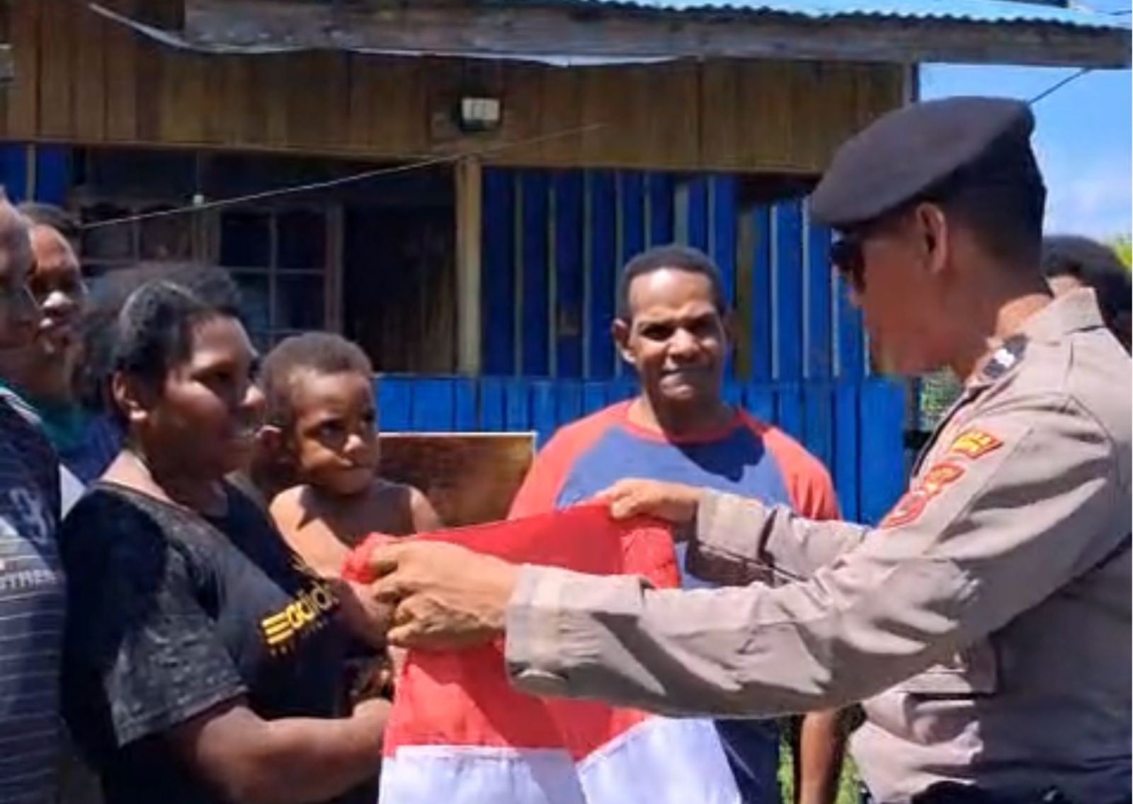 Anggota Polres Merauke membagikan bendera Merah Putih kepada warga. Foto: Humas Polres Merauke