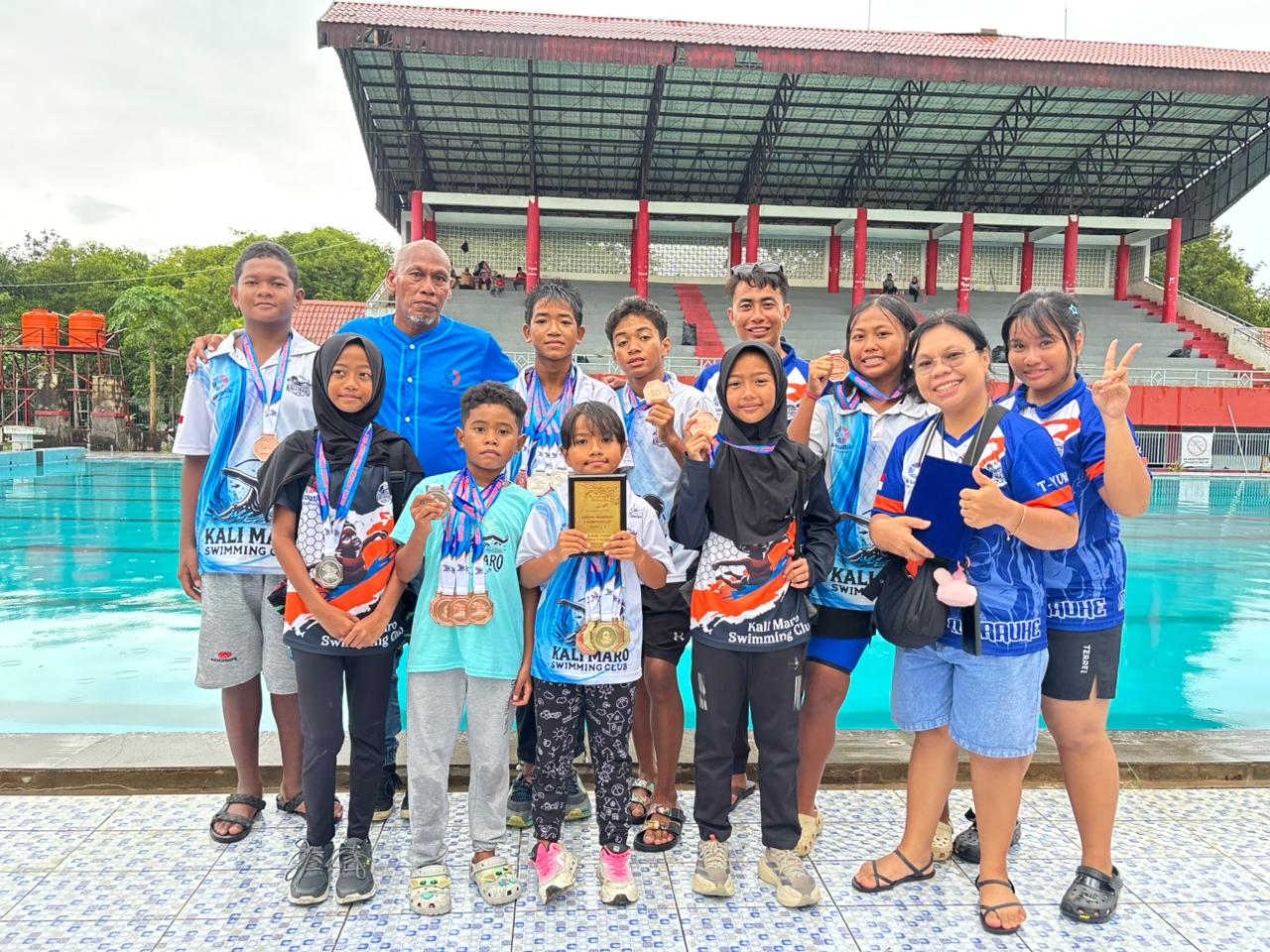 Pengurus Kali Maro SC Merauke foto bersama sejumlah atlet cilik binaan usai mengikuti ajang Anging Mammiri Championship Seri 3 yang berlangsung di Kolam Renang Universitas Hasanuddin, Makassar, 5–7 Februari 2026. Foto: Istimewa.