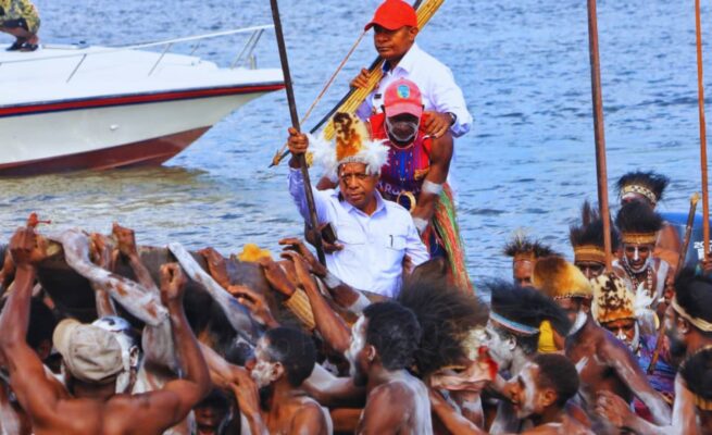Gubernur Papua Selatan, Prof. Dr. Ir. Apolo Safanpo, ST, MT, bersama Bupati Asmat, Thomas Eppe Safanpo, menaiki perahu tradisional dan dipikul puluhan warga ke atas bahu mereka menuju lokasi pertemuan bersama masyarakat. Foto: Bataspapua.com/Ist